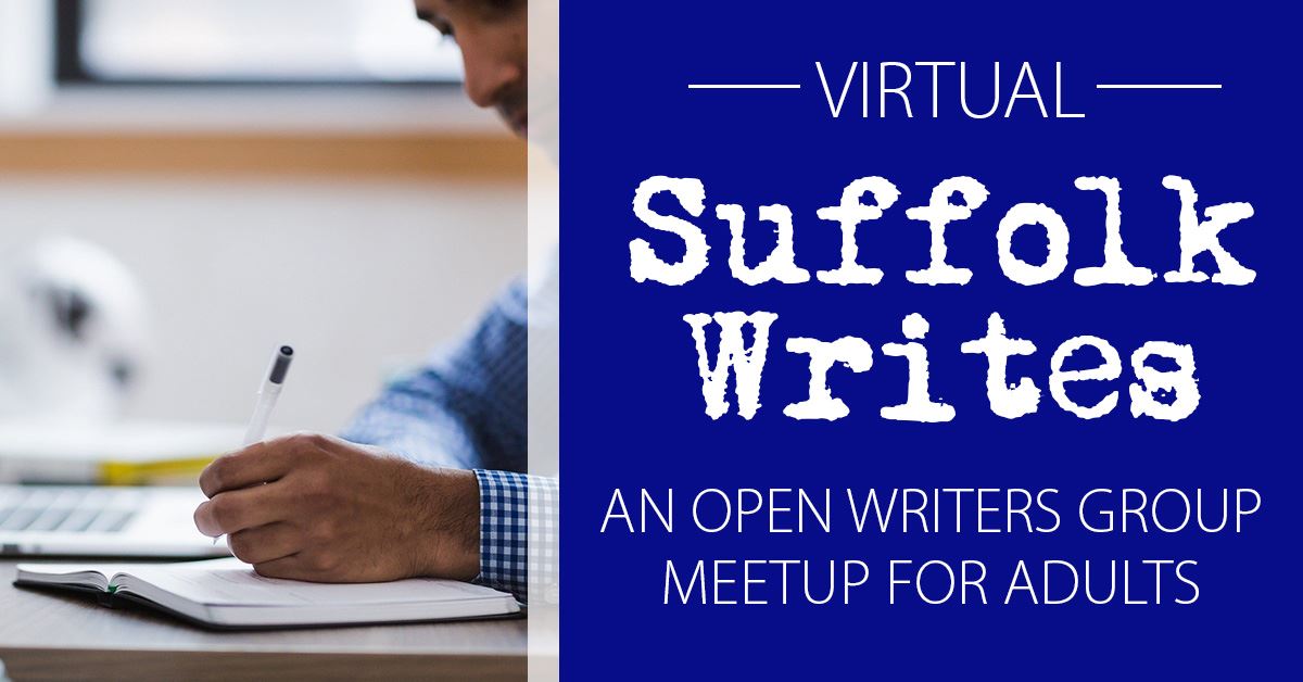 Man writing in book with laptop on table